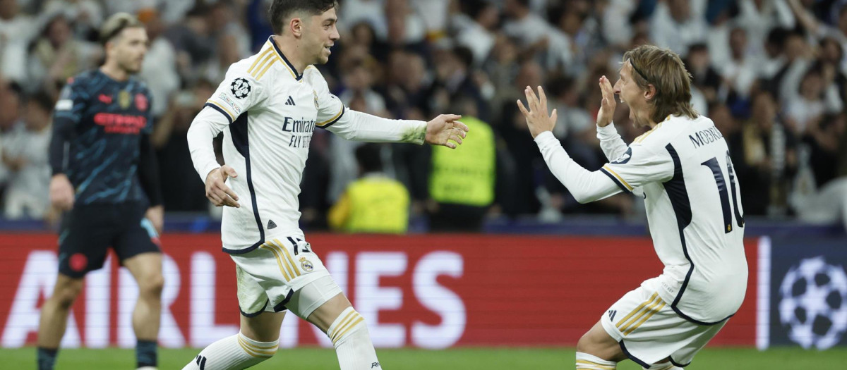 MADRID, 09/04/2024.- El centrocampista del Real Madrid Fede Valverde (i) celebra con Luka Modric su gol, durante el partido de ida de cuartos de final de la Liga de Campeones que Real Madrid y Manchester City disputan este martes en el estadio Santiago Bernabéu. EFE/Juanjo Martín