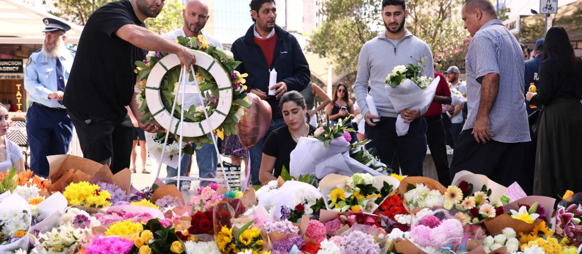 La gente deja flores y homenajes frente al centro comercial Westfield Bondi Junction en Sydney el día después de que un hombre con cuchillo de 40 años asesinara a seis personas