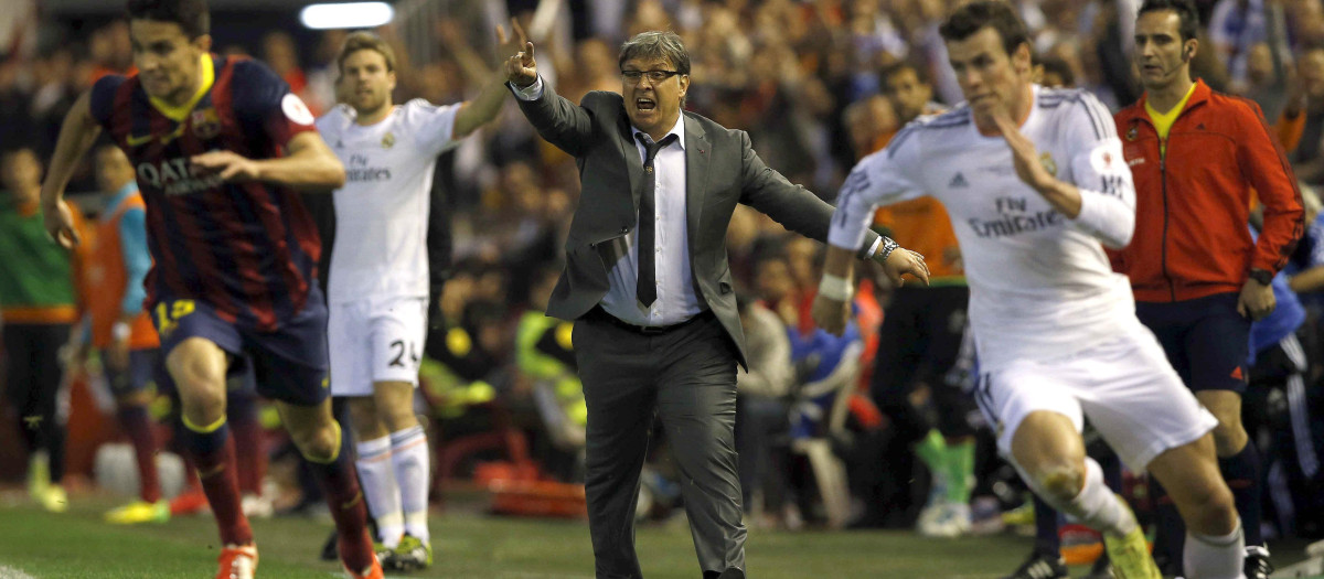 El entrenador argentino del FC Barcelona Gerardo Martino (c) durante la jugada en la que el galés Gareth Bale (d), del Real Madrid, se escapa de Marc Bartra (i) para conseguir el segundo gol del equipo blanco, durante la final de la Copa del Rey que disputan esta noche en el estadio de Mestalla, en Valencia. EFE/Alberto Estévez