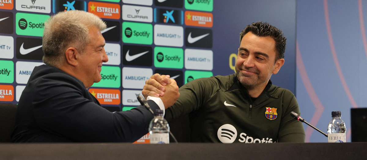 Joan Laporta y Xavi se abrazan durante la rueda de prensa