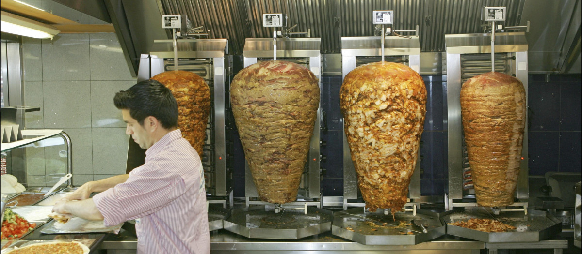 Un hombre prepara kebabs en un local de Hamburgo.