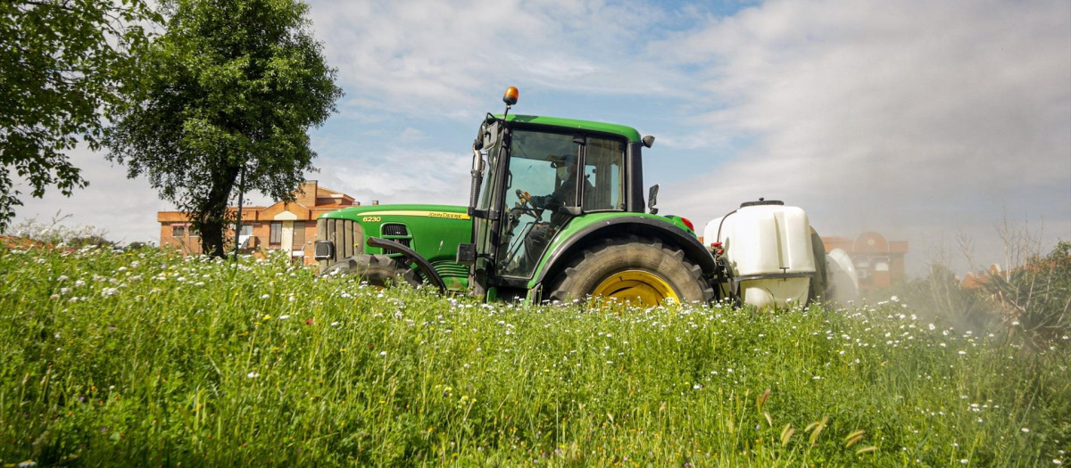 Un agricultor montado en su tractor desinfecta las inmediaciones de Aranjuez.