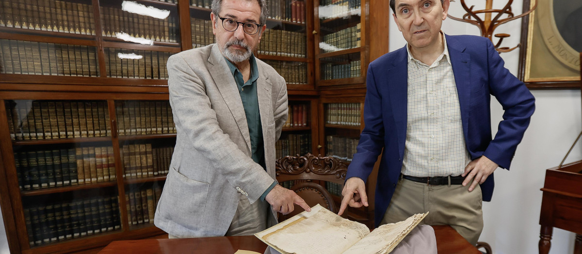 GRAFAND1133. SEVILLA, 10/05/2024.- Los profesores de Filología de la Universidad de Sevilla , Jose Solís (i) y Juan Montero, muestran el manuscrito en el que se puede observar la firma de Miguel de Cervantes, este viernes en la biblioteca de la Universidad sevillana .EFE /Jose Manuel Vidal