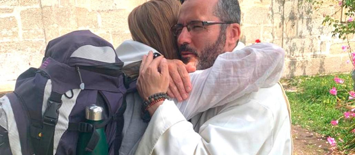 El padre Carlos despide a una peregrina en su ermita de Alba (Pontevedra)
