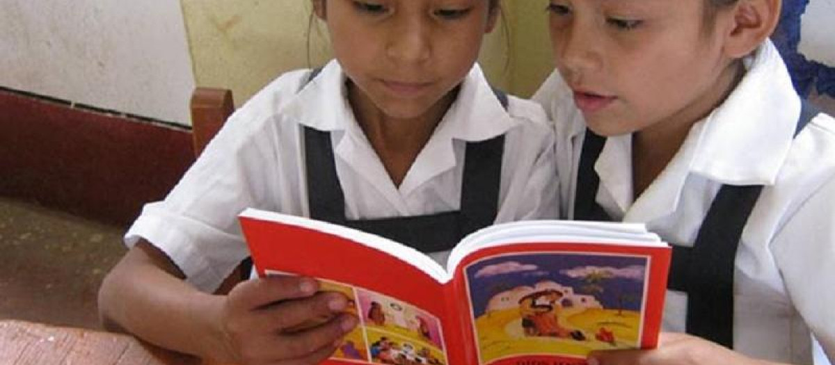 Don niñas leen un ejemplar de la Biblia