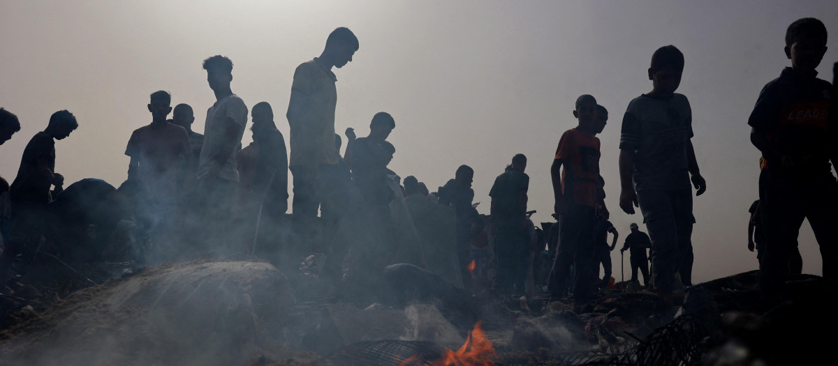 Los palestinos se reúnen en el lugar de un ataque israelí contra un campamento para desplazados internos en Rafah