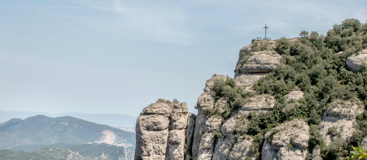 Una cruz corona una cima en la montaña de Montserrat, en Cataluña