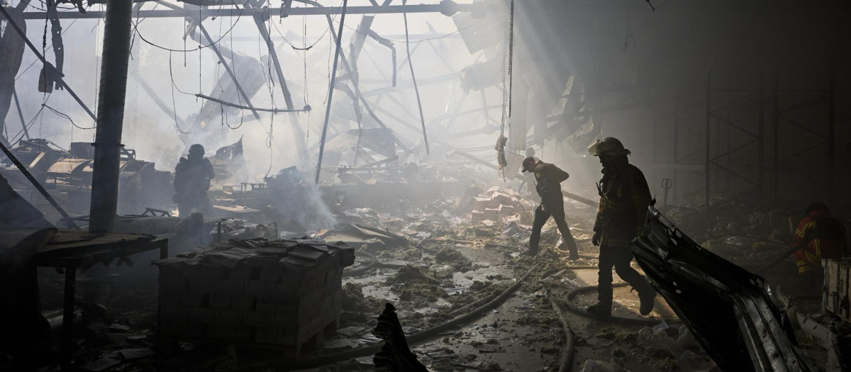 Rescatistas ucranianos trabajan en el lugar de un bombardeo contra una imprenta en Járkov, Ucrania, este jueves