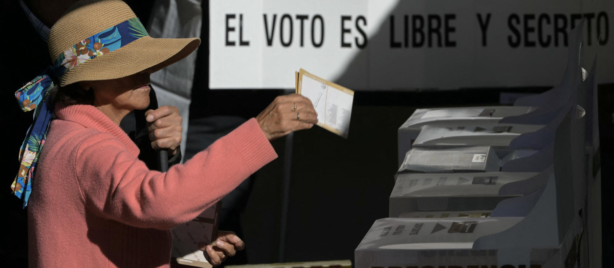 Una mujer deposita su voto en un centro de votación de la ciudad de México
