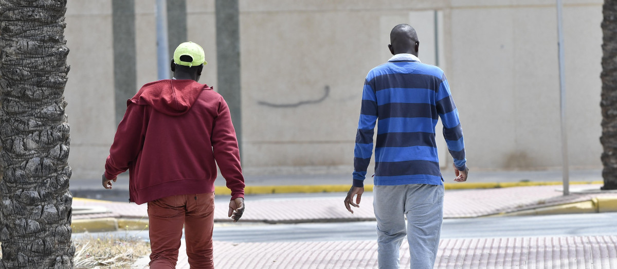 Dos inmigrantes subsaharianos pasean frente a establecimiento hotelero ?Ejido Hotel? en el municipio almeriense de El Ejido. El Ejido y Adra son dos municipios del Poniente almeriense que en las últimas semanas han mostrado su rechazo frontal a la apertura de centros de acogida temporal de inmigrantes procedentes de Canarias, aduciendo la presión migratoria y la alta frecuentación de pateras y narcolanchas en sus costas. EFE/ Carlos Barba