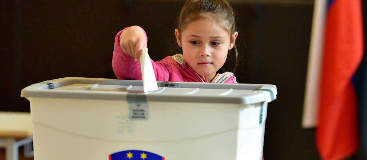 Una niña deposita un voto para las elecciones en Eslovenia