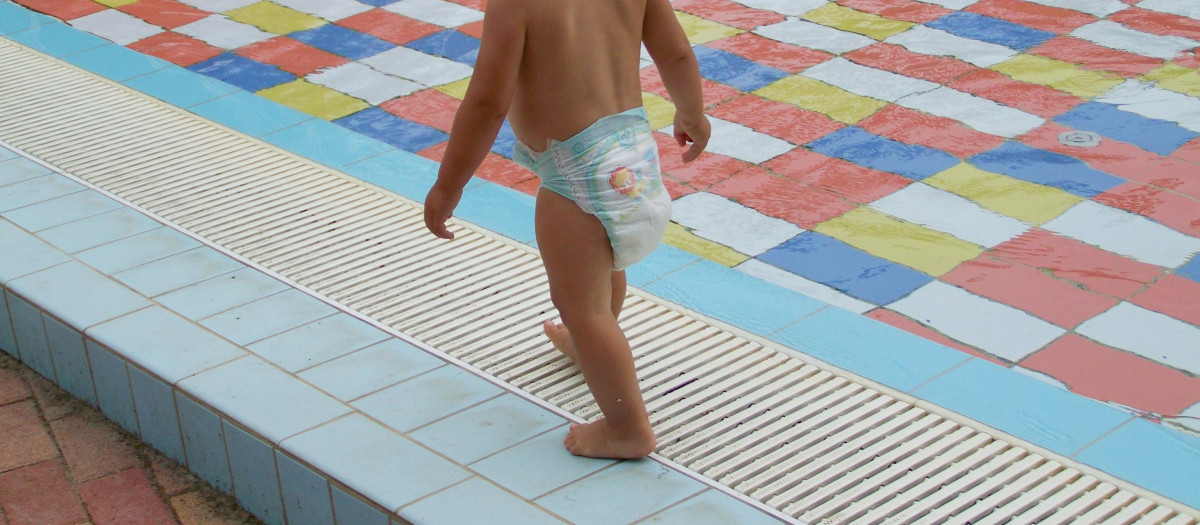 Un niño pequeño se alivia del calor en una piscina