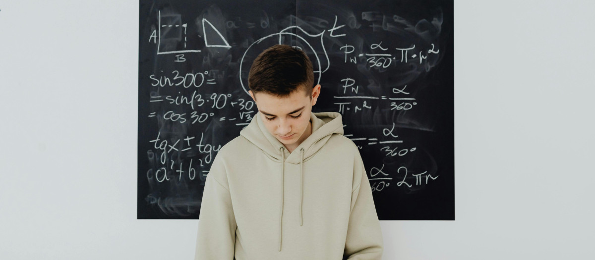 Un estudiante pensando delante de una pizarra