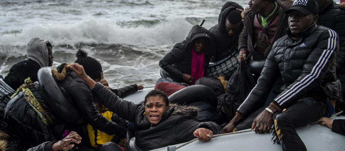 Inmigrantes en un bote en el mar frenete a la isla griega de Lesbos