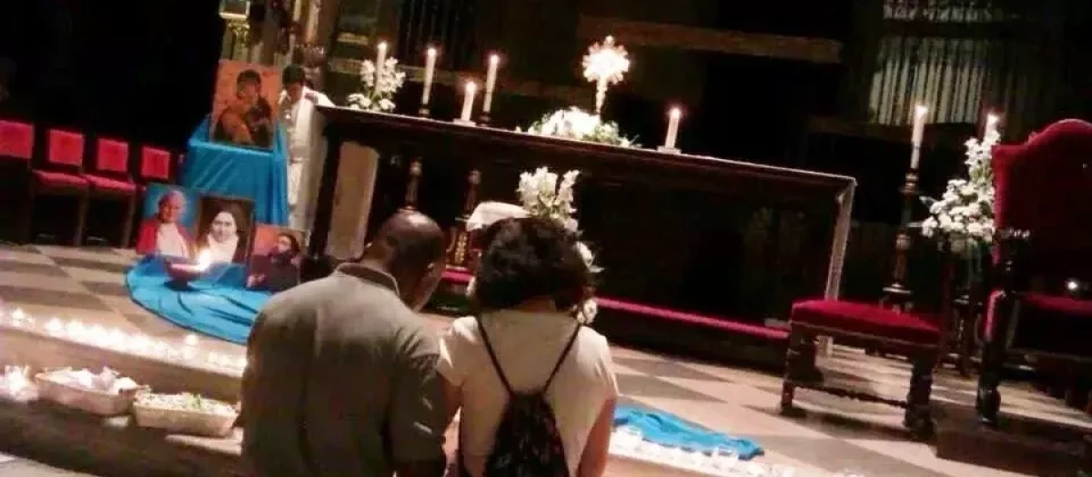 Una pareja reza ante el Santísimo expuesto en una iglesia de Alcalá
