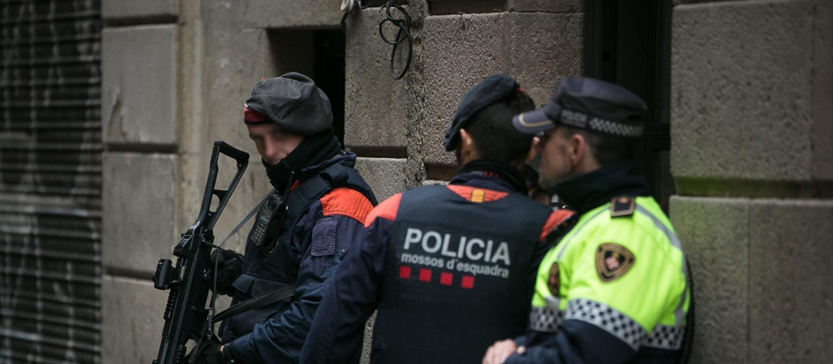 Dos agentes de Mossos d"Esquadra y uno de Guardia Urbana esperan en la puerta de un edificio del barrio de “El Raval”, en el distrito de Ciutar Vella de Barcelona, mientras otros compañeros efectúan registros en “narcopisos”.
Lola Bou / Europa Press
(Foto de ARCHIVO)
29/10/2018