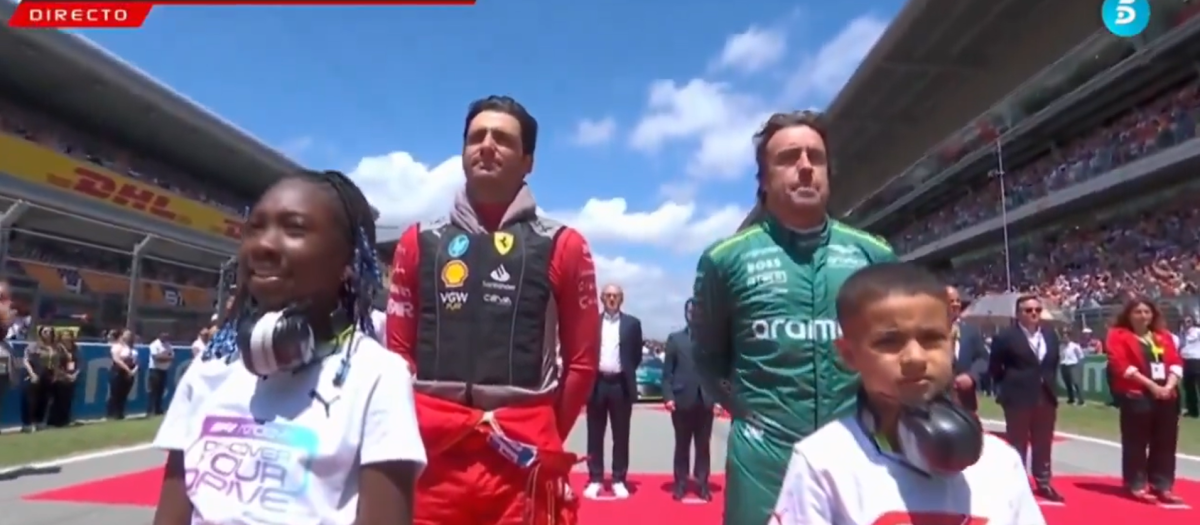 Fernando Alonso y Carlos Sainz durante el himno de España
