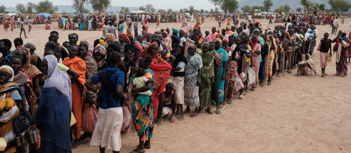 Mujeres y niños hacen fila para conseguir ayuda alimentaria en Sudán