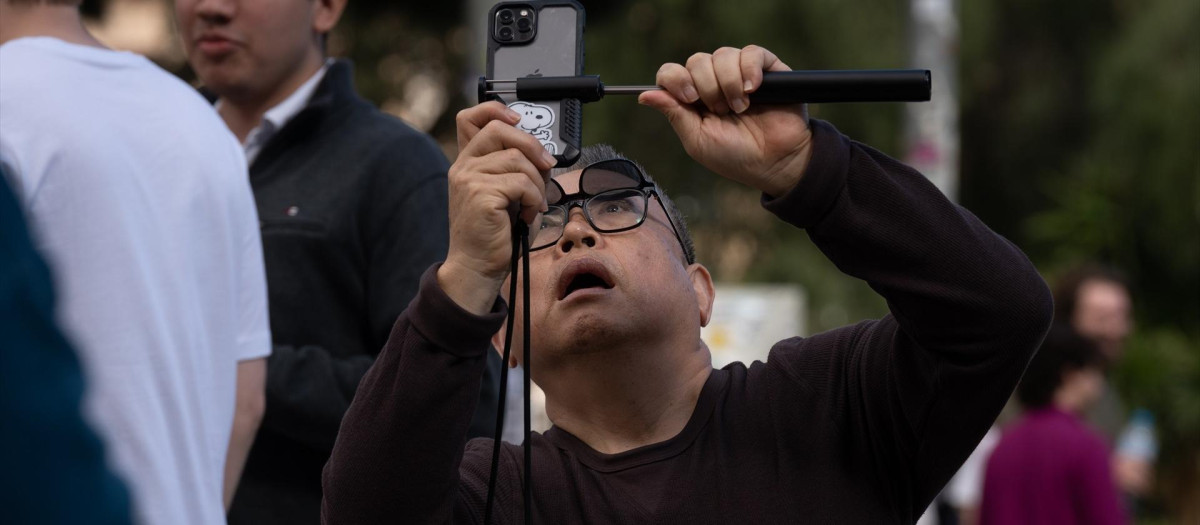 Un turista saca una foto junto a la Sagrada Familia.