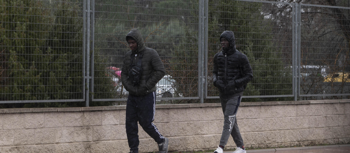 Dos inmigrantes caminan en las inmediaciones del centro de Emergencia, Acogida y Derivación en el Acuartelamiento 'Primo de Rivera'