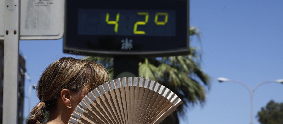Una mujer se abanica mientras pasa por un termómetro de calle que marca 42 grados n Córdoba