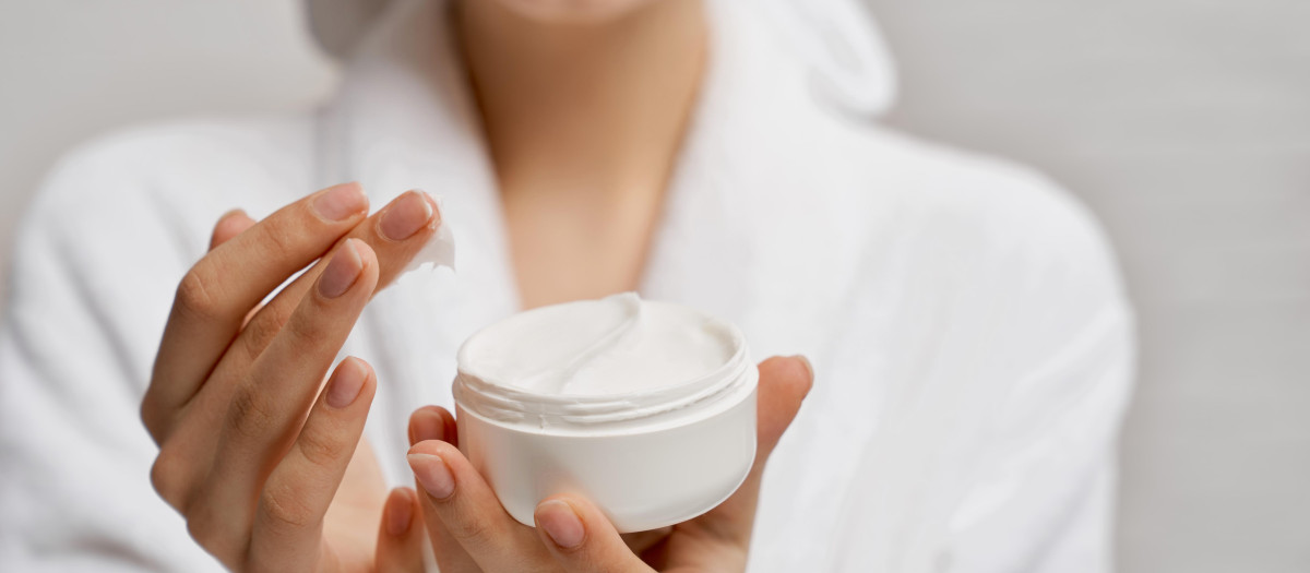 Mujer aplicándose crema en el rostro