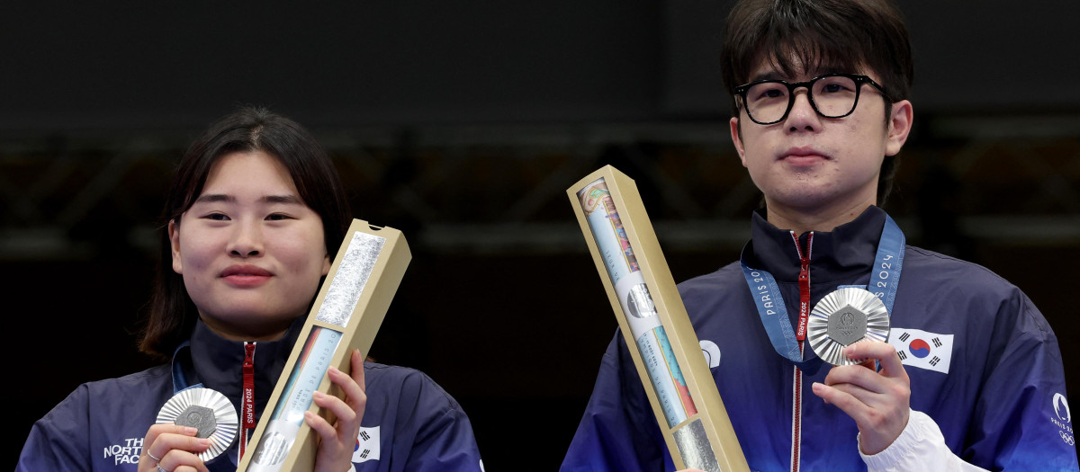 Los medallistas de Corea del Sur, Keum Jihyeonand y Park Hajun, posan con la medalla de plata en el podio