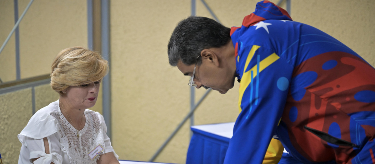 Venezuelan President and presidential candidate Nicolas Maduro votes during the presidential election, in Caracas on July 28, 2024. Voters in Venezuela began their ballots in the midst of political unpredictability, with incumbent Nicolas Maduro, who seeks a third six-year term, vowing a "bloodbath" if he loses, which polls say is likely as he lags far behind challenger Edmundo Gonzalez Urrutia in voter intention. (Photo by Juan BARRETO / AFP)