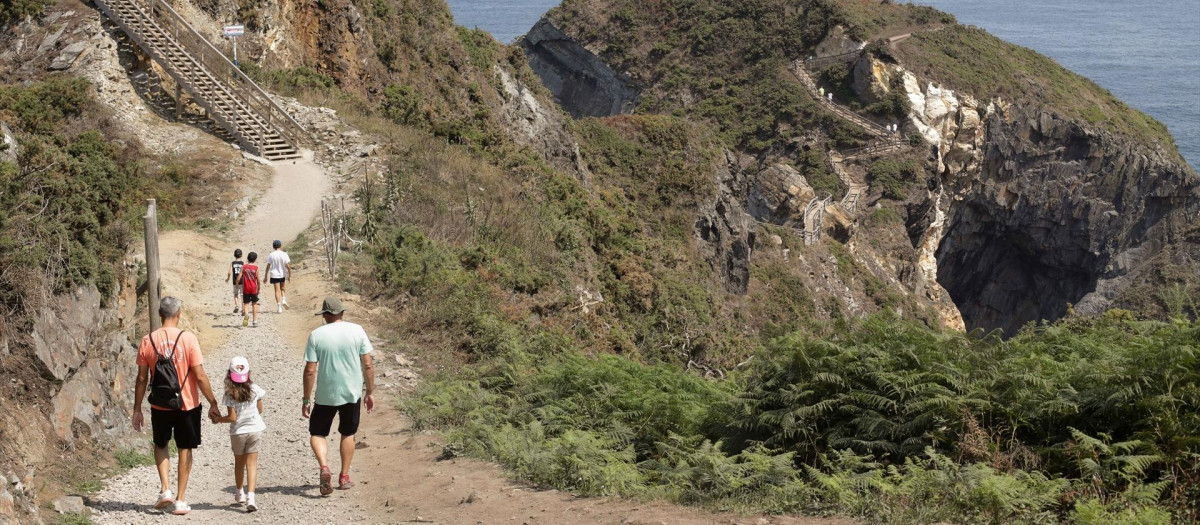 Unos turistas realizan la ruta Punta Socastro o ‘O Fuciño do Porco’, a 11 de agosto de 2022, en O Vicedo, Lugo