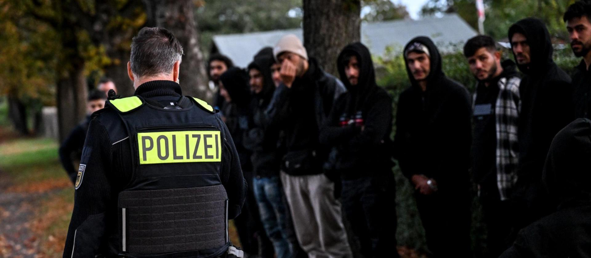 Inmigrantes hacen fila después de ser detenidos por la Policía en la frontera germano-polaca cerca de Frost