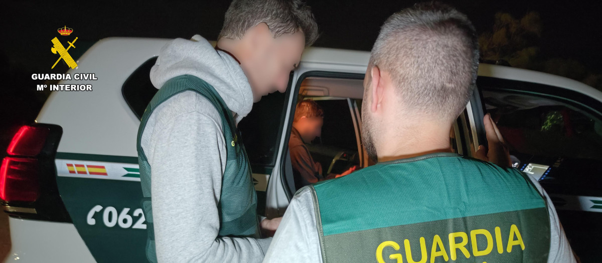 Dos agentes de la Guardia Civil de la UCO junto a Karim E.B en un vehículo del cuerpo, a su llegada a la comandancia de la Guardia Civil de Barbate.
