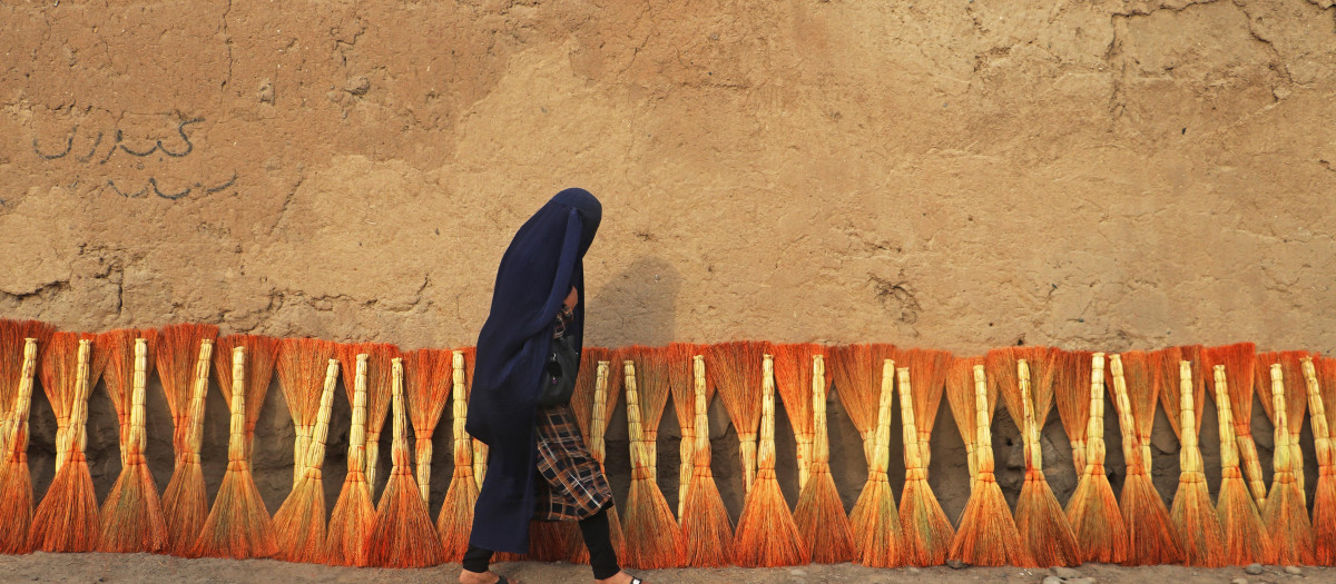 Una mujer afgana vestida con burka camina por una calle en el distrito de Fayzābād, provincia de Badajshán