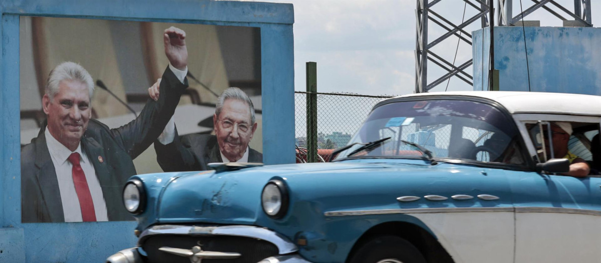 n carro clásico pasa frente a una fotografía del presidente de la República de Cuba Miguel Díaz-Canel junto a Raúl Castro hoy, en La Habana (Cuba)