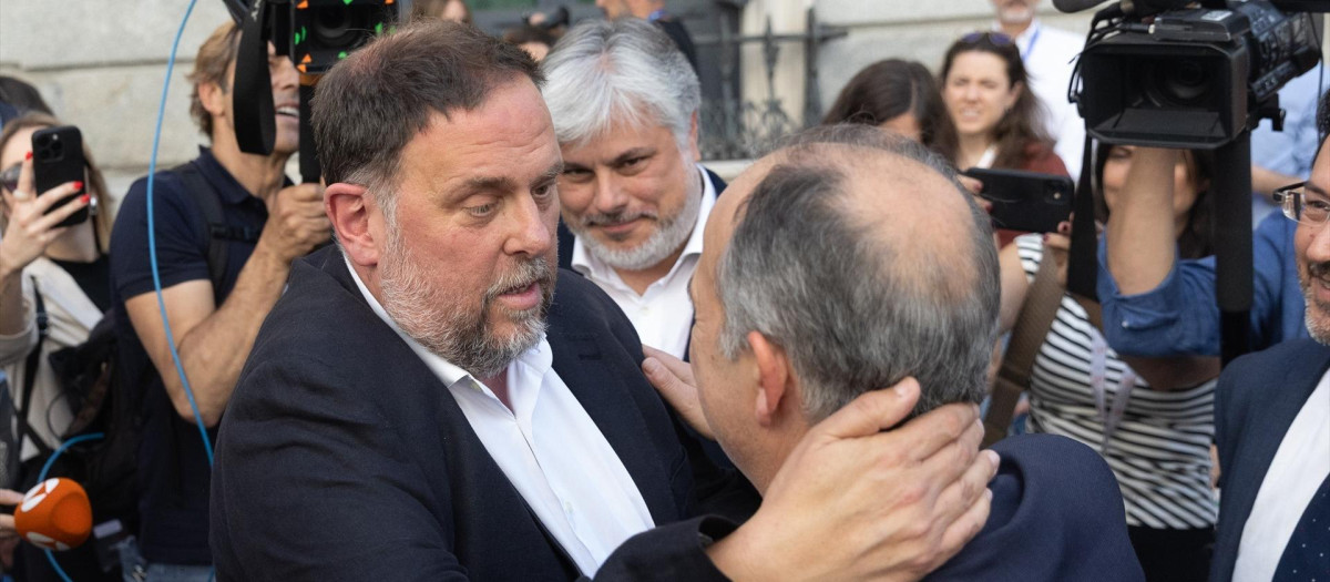 El presidente de ERC, Oriol Junqueras (i) y el secretario general de Junts, Jordi Turull (d), se abrazan tras quedar aprobada la Ley de Amnistía