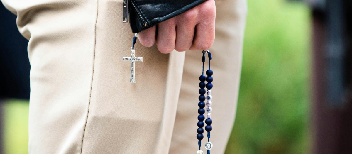 Un hombre reza el rosario por la calle