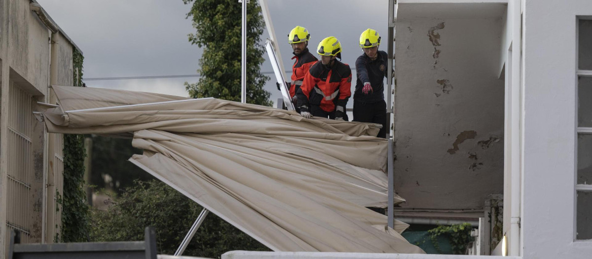 Bomberos de Santander retiran un toldo caído por el viento, este miércoles en la capital cántabra