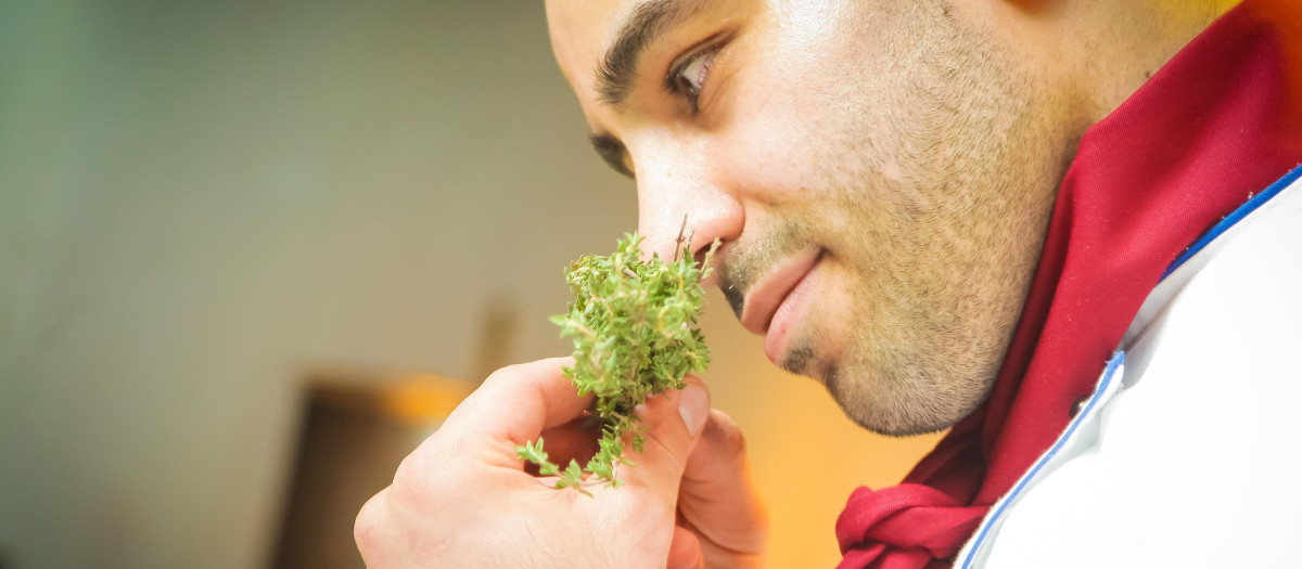 Un hombre oliendo una planta