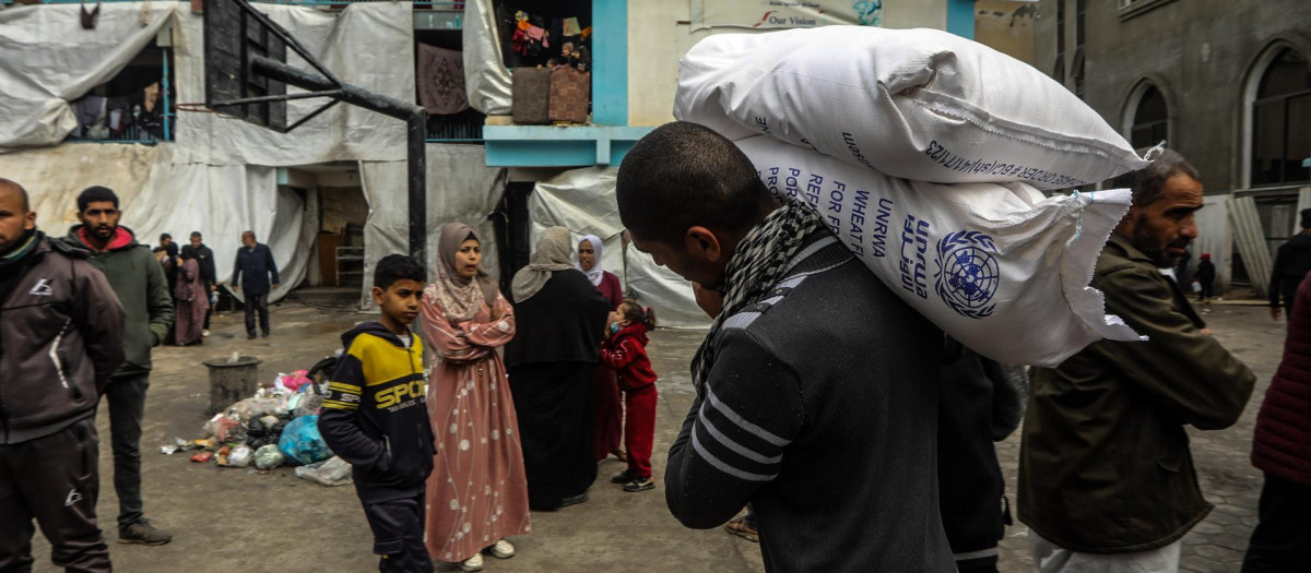 Palestinos desplazados reciben ayuda humanitaria en Rafah, al sur de Gaza