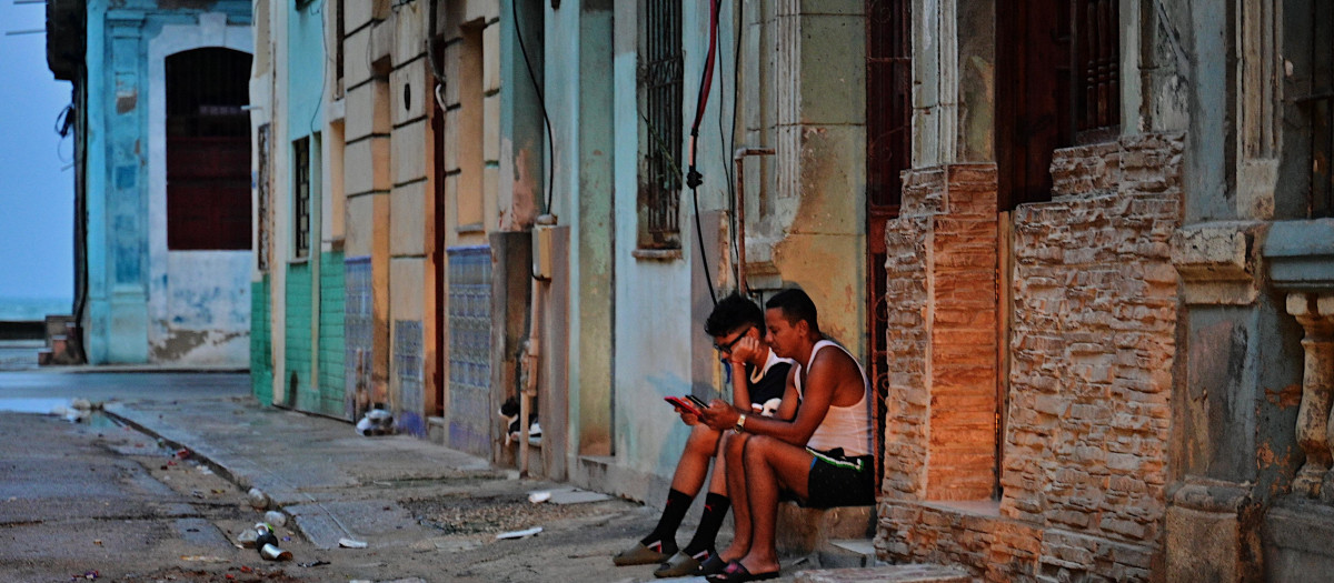 La gente revisa sus teléfonos durante un apagón nacional provocado por una falla en la red eléctrica en La Habana