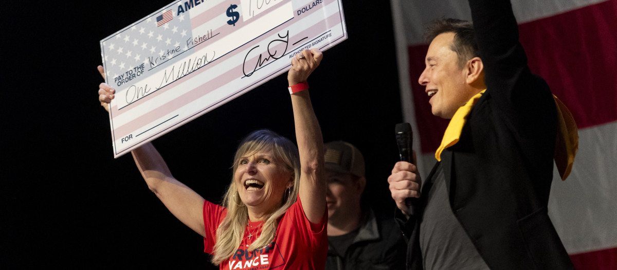 Elon Musk entregando el cheque de un millón de dólares a una votante de Pittsburgh, en Pensilvania