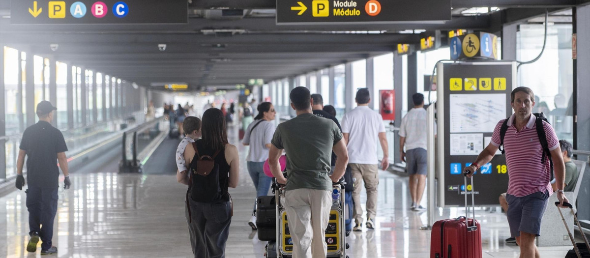 Varias personas con maletas en la terminal T4 del aeropuerto de Madrid-Barajas.