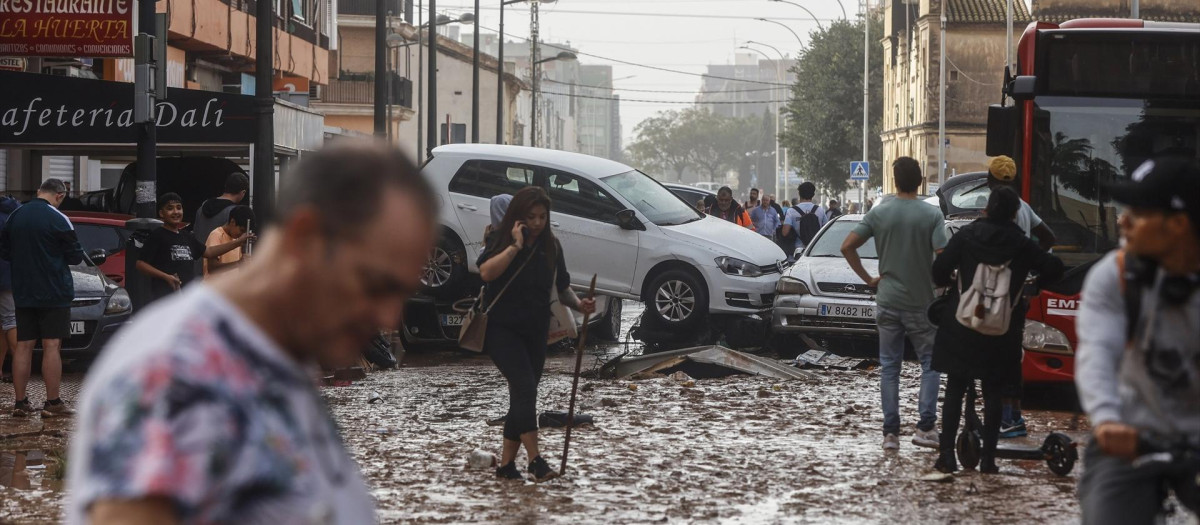 Varias personas realizan labores de limpieza tras el paso de la DANA por el barrio de La Torre de Valencia