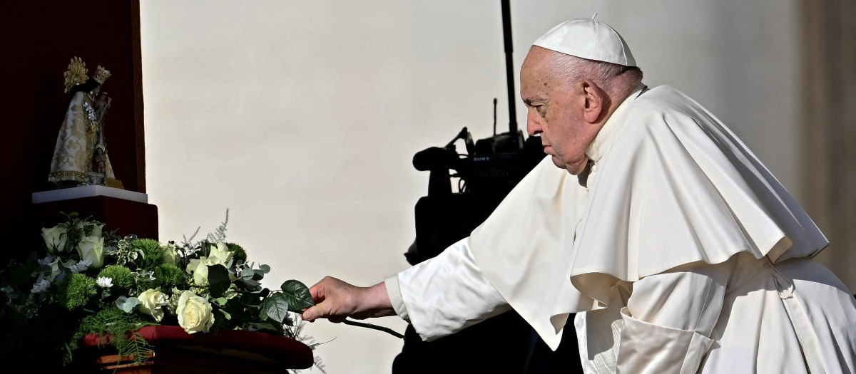 Pope Francis lays a white rose on the statue of the Madonna of Valencia before the weekly general audience in Saint Peter's square in The Vatican on November 6, 2024. (Photo by Filippo MONTEFORTE / AFP)