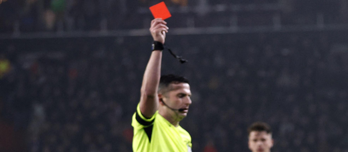 Un árbitro enseña una tarjeta roja directa tras una salvaje entrada