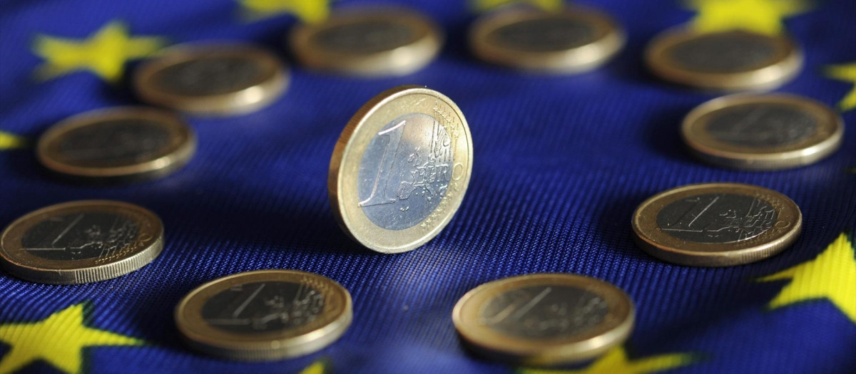 Euro coins lie on a Euro flag.