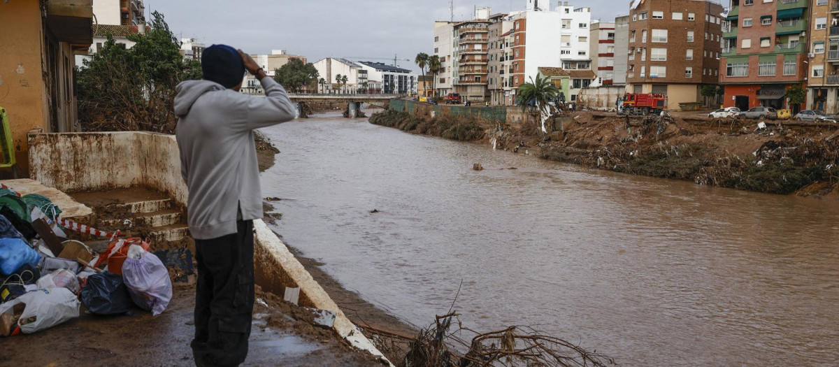 Un hombre observa el caudal del Barranco el Poyo