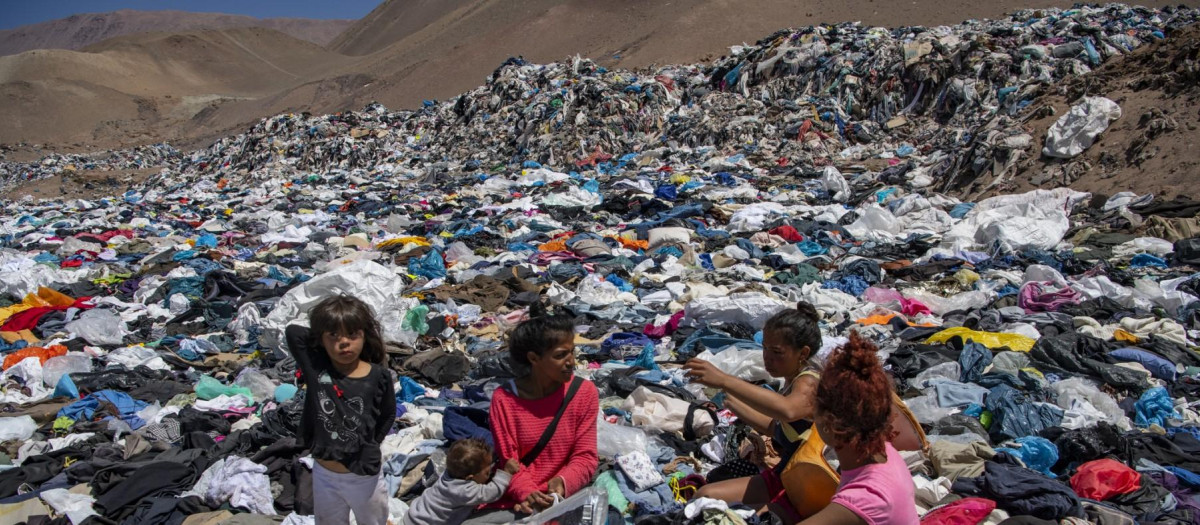 Varias mujeres buscan ropa usada entre toneladas de desechos en el desierto de Atacama