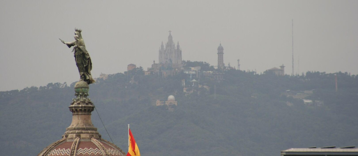 Vista de la estatua que corona la Basílica de la Mercè, con el Tibidabo al fondo