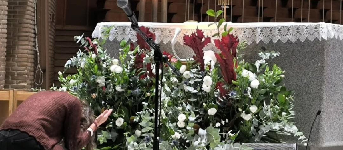 Una mujer se arrodilla ante el Santísimo durante la alabanza