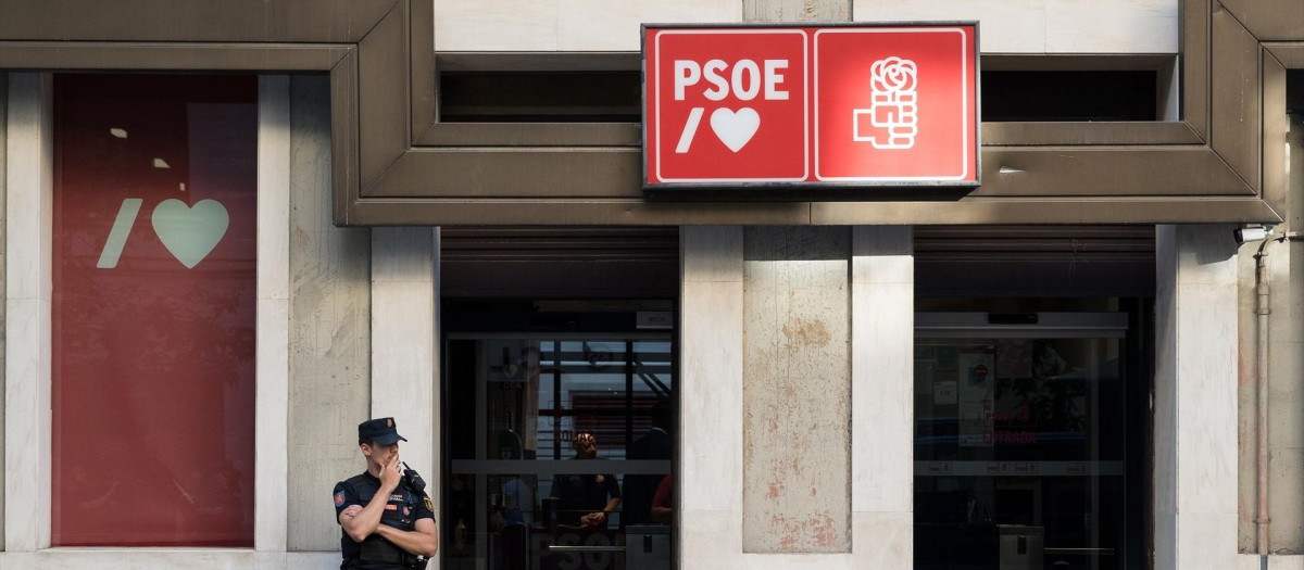 Un agente de Policía aguarda en la entrada de la sede del Partido Socialista (PSOE) en la calle Ferraz
